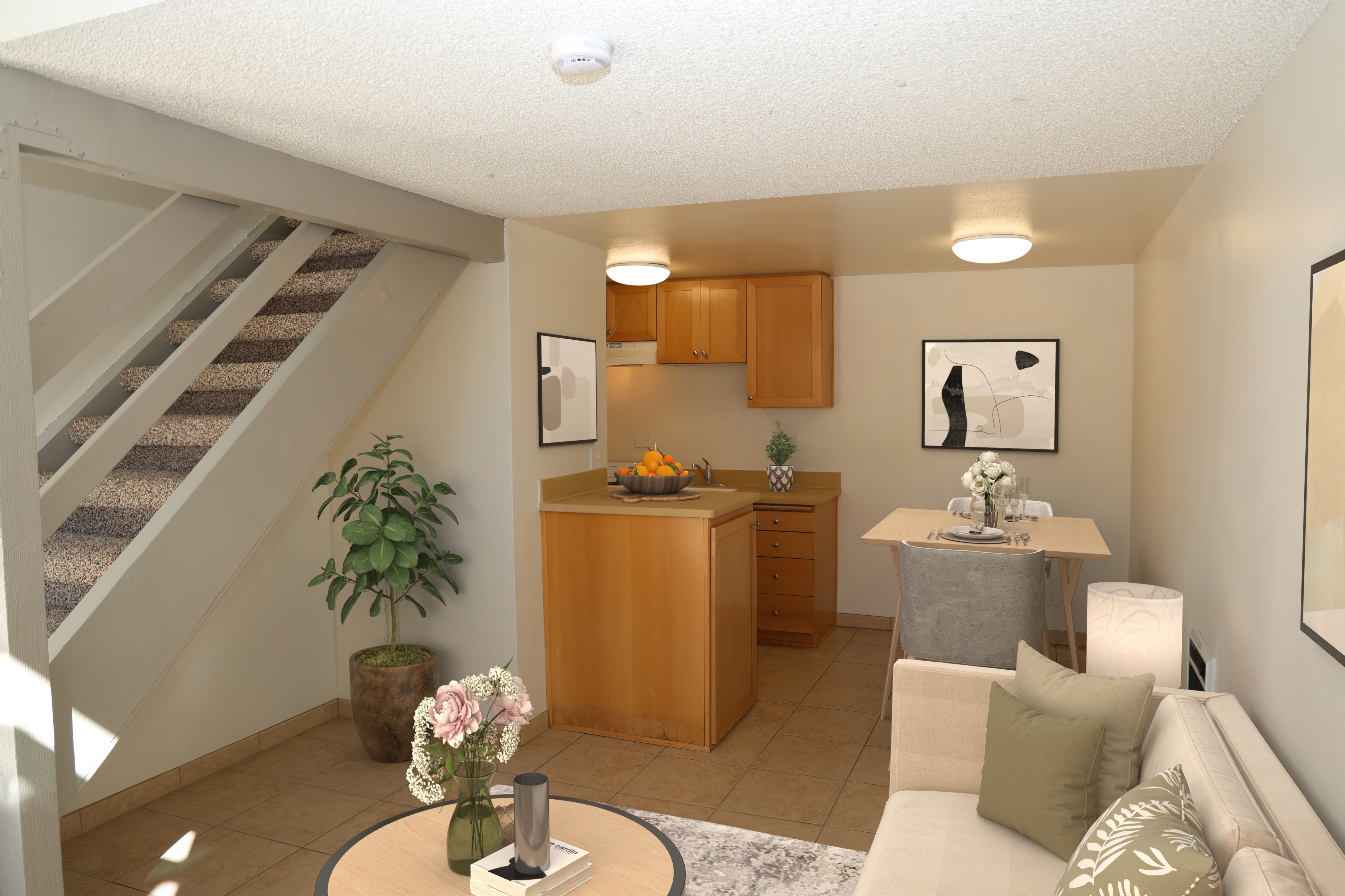 Bright studio apartment with kitchen, dining area, and staircase to a loft